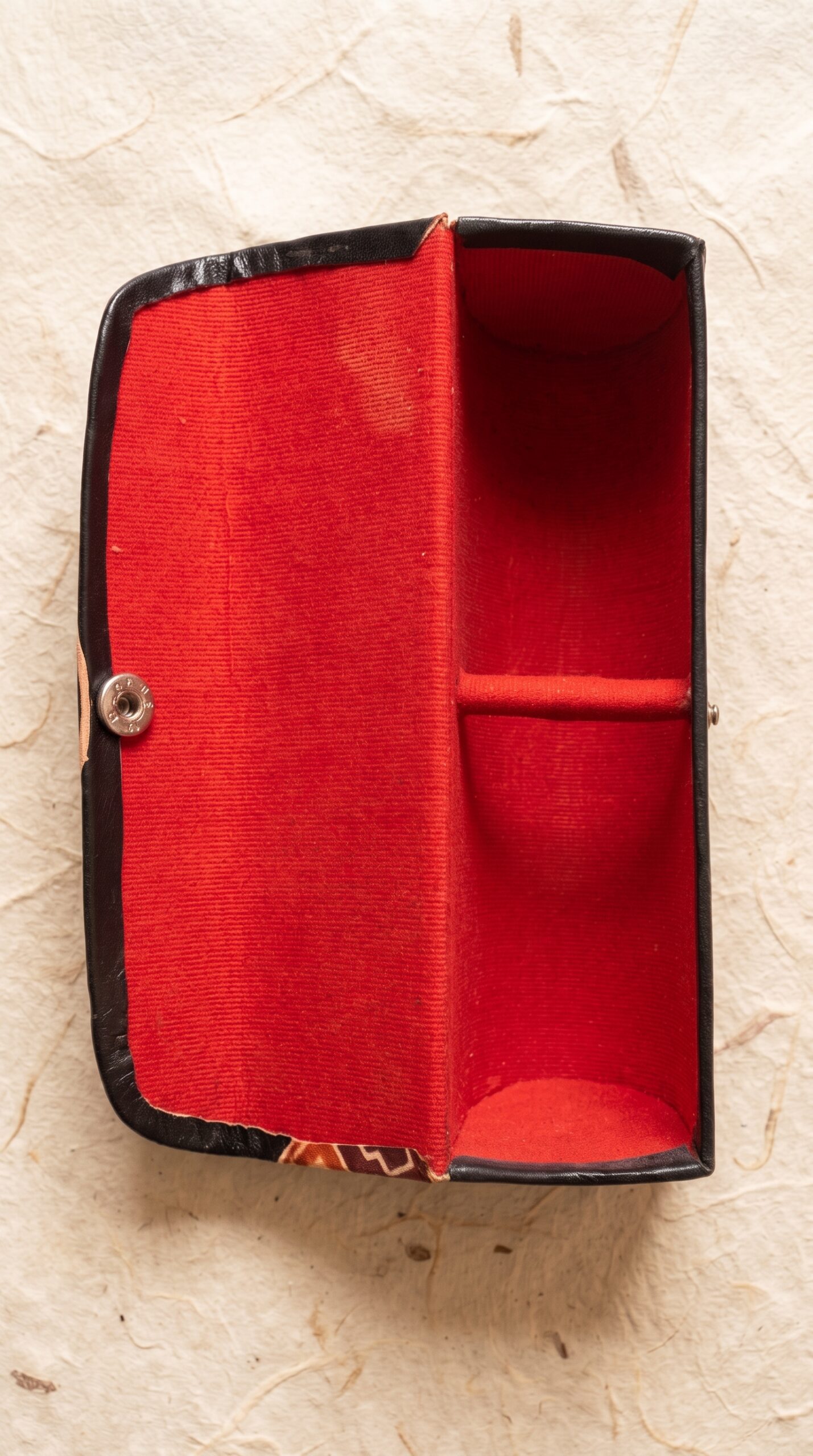 Interior of hand embossed genuine leather sunglass case showing red velvet lining